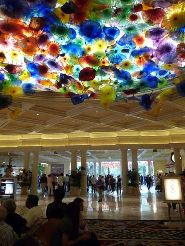 ベラージオのエントランス。<br />ちょっと悪趣味な気もするベネチアングラスの豪華な天井。<br />さすが有名ホテル、ロビーは人でいっぱい！<br />私達はレイクビュー指定の部屋では無かったのでスタッフゥに一応交渉してみたんだけど、<br />あいにく当日はSOLDとの事。<br />期待していなかったけどやっぱり残念。金払えってことデスネー。