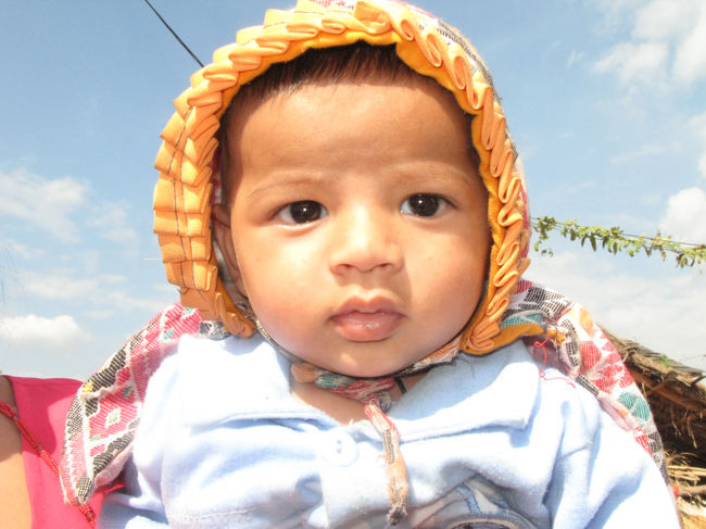 カメラの前に差し出された赤ちゃん、泣かないでね