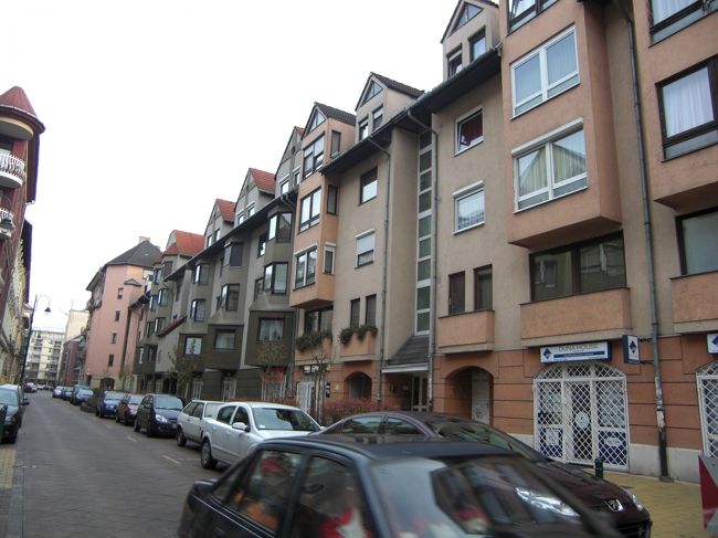 共産主義時代の集合住宅タイプの町並みで、駐車場がないらしく、すべて路駐。走っている車はほこりだらけ。