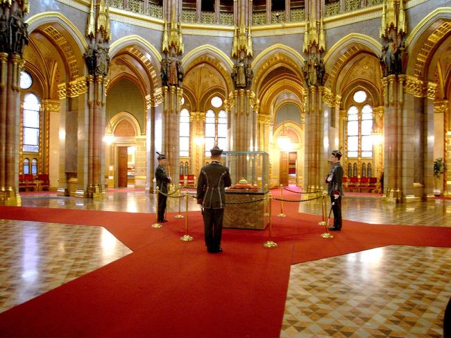 議事堂のほぼ中央、ドーム天井部の真下に<br />歴代ハンガリー王の王冠があります。<br /> この王冠は初代イシュトヴァーン戴冠の1000年から、最後の王カーロイ（カール）４世が１９４８年に退位するまで王から王へと受け継がれてきたものらしいです。<br />　<br /><br />