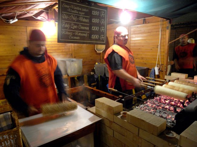 円筒形のパン菓子。イースト生地でパリパリに焼いてあります。<br />注文すると、写真左のおじさんが砂糖をまぶしてくれます。<br />ウォルナット味を頼んだら、砕いた胡桃とグラニュー糖をたっぷりかけてくれました。<br />これが、香ばしくておいしい！！<br />焼きたてのホカホカもいいのですが<br />次の日、しっとりした味もなかなかでした。<br />駅の売店でも売っていたので、名物なんでしょうか？