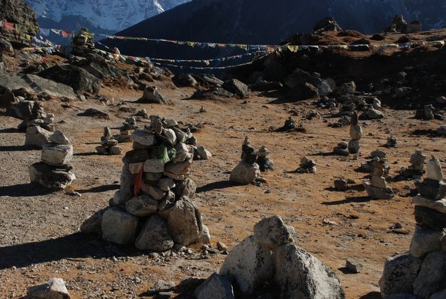 ペリチェの集落が眼下に見えます。<br />ヒマラヤの霊峰に向かってチョルテンと石塔が<br />並ぶ峠です。<br />ヒマラヤ登山に従事したポーターやシェルパの墓<br />だともいう。<br />霊峰に向かって祈りの石塔は並ぶ。<br />
