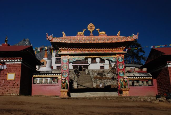 タンボチェの寺院<br />　朝日に輝いて見えました。<br />　往路の風景とは違います。<br />　<br />タンボチェは大きなタンボチェゴンパ（僧院）で有名。漏電火災により焼失、1995年に再建。夕方の読経の寺院に入れてもらう。光の無い闇の世界に僧侶の読経は響く。太鼓、笛､鐘の音は私の心の底までずっしりと響く。厳粛な一時を過ごさせてもらう。感動と体験でした。1999年記より<br /><br />あれから3回夕方の読経に参列するが<br />明るい寺院の中は年代とともに変わった。<br />門戸開放の明るさがあった。