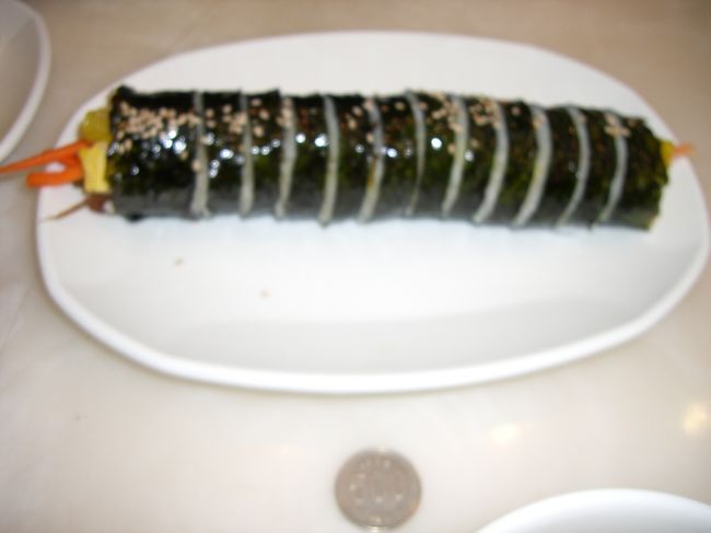【ＣＯＥＸ】<br />一緒に頼んだキンパッ（海苔巻き）<br /><br />韓国でキンパッを食べたことがなかった私。<br />日本の海苔巻きは、酢飯だけど韓国は味がついていないご飯。<br />私は、韓国流の方が好きかも。<br />それにしても、デッカイ！<br />最後は、譲り合い。っというかお互い擦りあい。