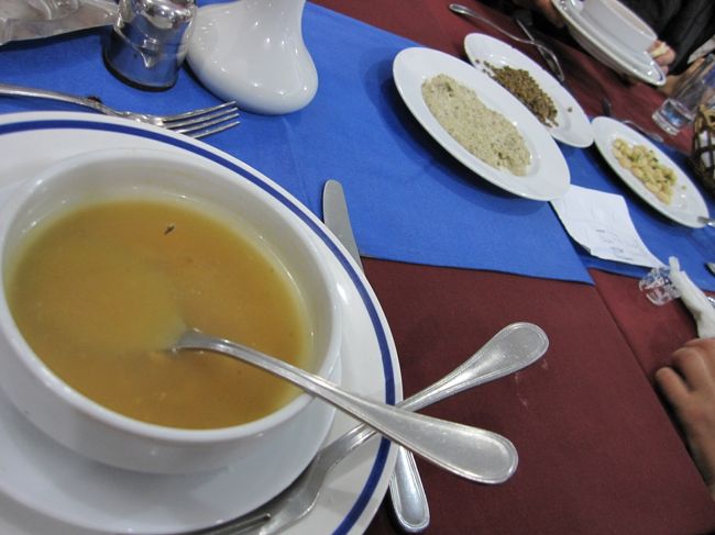 レストランに着くと夜のナイル川沿いで、結構肌寒い。テラス席はきついかなー。と思っていたら、室内へ通された。<br /><br />ふと外へ目をやると、ん？全部の窓にガラスがはめられていない？<br /><br />ちょい寒いけど食べれば温まるかあー。<br /><br />最初にパンと野菜のスープ。<br />エジプトのスープは、たいてい塩味はきいておらず、旅の最終日まで、食事中は塩、こしょうが皆の間を回っていた。<br /><br />奥に見えるのは、パンに付けるのであろう、少しすっぱいタルタル、のようなソース。（これは驚くくらい本当にどこででも出てきた。エジプトではポピュラー？）<br /><br />あとは山椒がきいたような、豆と、甘い白豆？があった。<br />