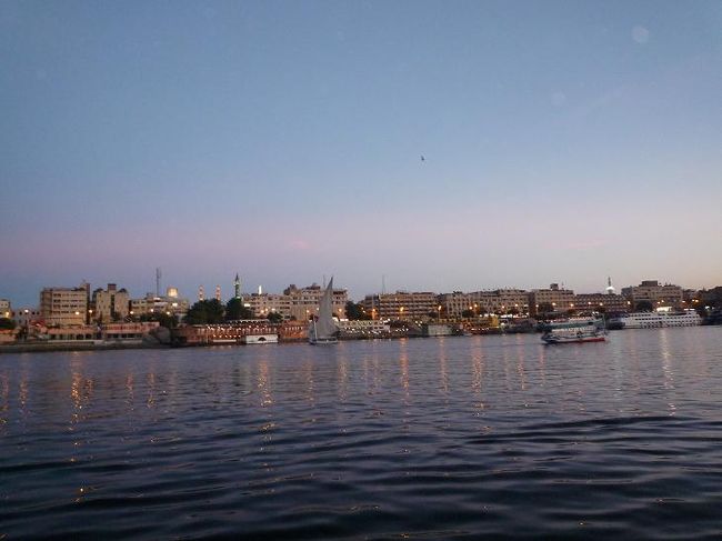 アスワンに戻るとポーターの人がタクシーも手配済みで、スムーズに宿泊するホテルの船着場に到着することが出来ました。チェックインに少し時間が掛かりましたが、ホテルも部屋も広くリゾート気分に浸れました。シャワーを浴びてプールサイドで休憩し、夕方になると船で対岸にある地元のレストランAl-Masryへ食事に出かけました。美味しいエジプト料理に大いに満足した後、すぐ近くにあるスークへ繰り出しました。<br /><br />アスワンのスークはスゴイです。その想像以上の大きさと活気に圧倒されました。多種多様なお店が所狭しと並び、掛け声の飛び交う中を人々が行き交っていました。女性や子供も多く夜遅くても安心でした。何といってもここのスークは観光客だけを相手にしているのではなく、地元の人達の日常生活に必要な物を売っていました。<br /><br />(写真：アスワンの夜景)<br />