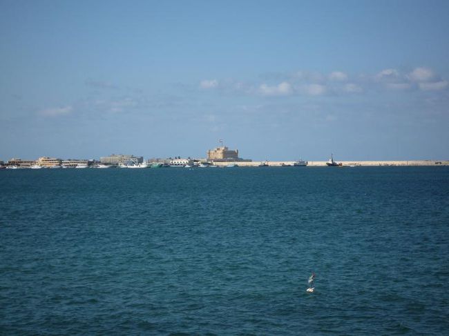 国立博物館を出た後は海岸沿いの道路を歩きました。この日も晴天。空も海も爽やかなブルーです。心地よい風に吹かれてしばらく海岸沿いを歩き、オラービ広場を過ぎたところにある“Kadoura”でシーフードの昼食をとりました。味も良く窓から海とカーイトゥベーイの要塞が見渡せて景色も最高でした。その後、海沿いの道を離れたのが間違いだったのか、道に迷ってしまいました。雰囲気が良くない地区では、道端にガラクタを並べて売っていました。でも、フリーマーケットとは違う怪しい雰囲気がありました。盗んできた物？やどこから仕入れたか判らないようなものばかり並んでいて、これが“泥棒市”？と思いました。そこにいた人達が商品ほど怪しくなかったので助かりました。声を掛けられることも無く、無事に通り過ぎました。<br /><br />（写真：アレキサンドリアの海岸）<br />