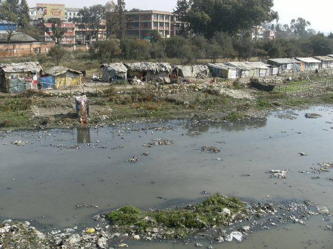 <br />　　パグマティ川に架かる橋から川岸に目をやると・・<br /><br />　バラックが密集、