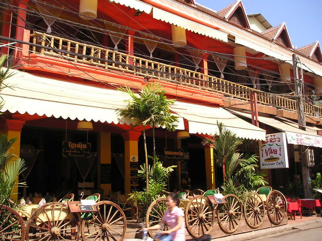 　朝の８時にはシェムリアップの空港に着いたというのに、<br /><br />　遺跡を見に行くでもなく、シェムリアップの町をぶらぶらしました。<br /><br />　町ではトゥクトゥクが、<br /><br />　｢一日５ドルでどう？｣<br /><br />　なんてしきりに声をかけてきます。<br /><br />　｢結構大変なんだね、トゥクトゥクも。｣<br /><br />　｢この世界同時不況のあおりで観光客が減ったのかもね。」<br /><br />　なんて、人の心配をしている場合じゃないんですが。<br /><br /><br />　ホテルのフロントでは、<br /><br />　｢遅くとも１１時までにはお部屋を準備しておきます。｣<br /><br />　とのことでしたが、シェムリアップの町歩きは思いのほか楽しくて、<br /><br />　オールドマーケット近くで昼食を取って、ついでにフットマッサージを受けて帰ってきたら、午後１時を回っていました。<br /><br />〔写真：お昼を食べたレストラン。〕