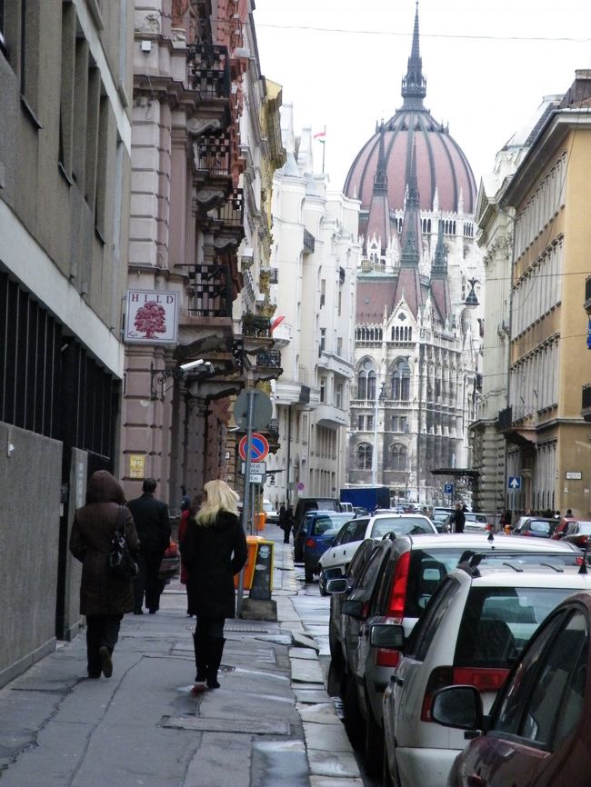 国会議事堂へ通じる通り。<br />屋根のエンジ色は、それまで見た絵葉書や写真では安っぽい色に見えたが、現物は落ち着いた青を感じる赤紫でとても美しかった。<br />道路には車が無造作に駐車して風景を塞いでますが、絵を描く人にとっては目に入らないものです。写真コンクールでは没ですね。