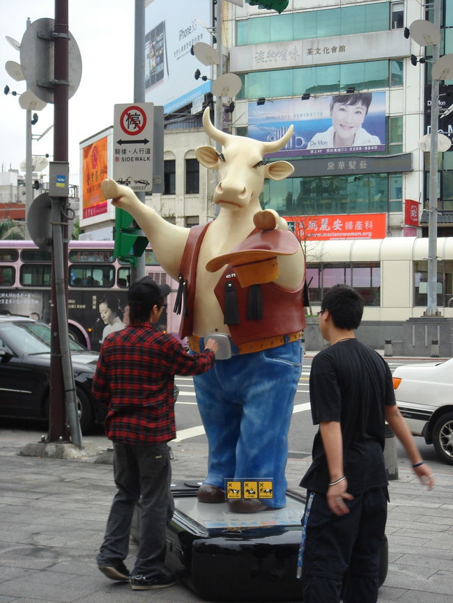 牛が持っている帽子に、少年達が小銭を投げ入れていました。