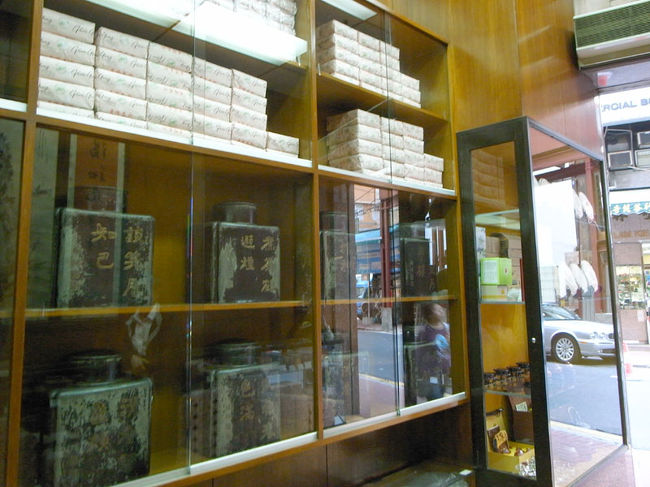 次に、蔡瀾氏の本でおすすめされていた、<br />上環のお茶屋さん、｢嶢陽茶行｣へ。<br />創業何百年かの歴史あるお茶屋さんらしい。<br /><br />初めて入る店では、やっぱり少し緊張するけど、<br />とりあえず｢Ｈｅｌｌｏ！｣とかいいつつ店へ。<br /><br />商品がディスプレイされているカウンターのおじさん、<br />入口で迎えてくれたおじさんは、ニコニコ顔でびっくり。<br />香港の人って、基本的に愛想がないってイメージだったんだけどなー。<br />(仲良くなると、そうじゃないと思うけど、<br />店員さんは大体愛想があんまりないし…)<br /><br />｢まずは座って〜｣という感じで、<br />Ｎｏ．2のクラスだという鉄観音茶をいただく。<br /><br />1口飲んで、めっちゃおいしい!!と思った。<br />結構濃い味なんだけど、後味がすっきりしているというか。<br />あっという間に飲みきり、飲むたびに注いでくれるので、<br />4杯くらいごちそうになったかな。<br />習いたての廣東語で、<br />｢好好飲!!(めっちゃおいしい)｣を連発。<br />｢そうか〜｣みたいな感じで、おじさんたちも笑顔。<br /><br />途中、英語ができるおばさんが奥から出てきてくれて、<br />いろいろ話をしてくれて、ランクも様々な鉄観音から、<br />｢Ｎｏ．2で十分よ｣みたいなおすすめをしてくれた。<br /><br />でも、Ｎｏ．2でこれほど美味しいのなら、<br />Ｎｏ．１はどれだけ美味しいのか、<br />とりあえず気になったので、1と2を購入。<br /><br />嬉しかったので、ついでに、おじさんたちと<br />記念写真を撮ってもらった。<br />最後にみんな出てきてくれて、<br />手を振ってばいばい。<br /><br />お茶も美味しいし、雰囲気もいいし、<br />いいお店だな〜、ホントに。