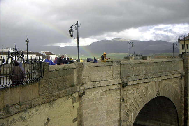 プエンテ・ヌエボ橋　虹も<br /> <br />ここから、ＭＡＹＵＭＩさんのガイドで歩いてロンダの街を見学する。<br />パラドールの脇に有る、プエンテ・ヌエボ橋を渡る。グアダレビン川によってえぐられた渓谷はこの町を二分しているが、その掛け橋がこの橋で、18世紀に架けられ、全長１００メートル以上に渡って旧市街と新市街とを結んでいる。橋から見る渓谷の景色も絶景である。まだ小雨がパラついており、橋の上には虹が掛っていた。<br /><br />
