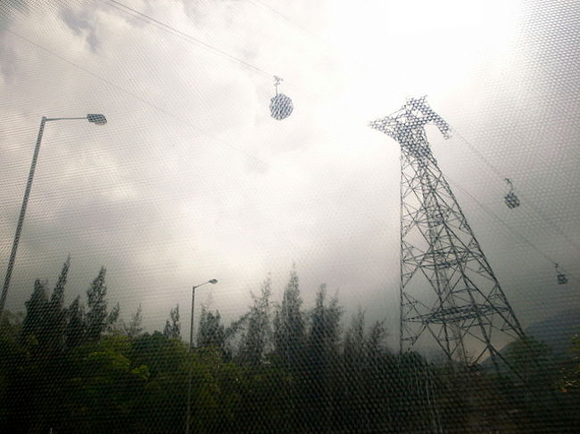 いつもは、時間優先なので機場快線<br />(エアポート・エクスプレス)を使って<br />ささーっとホテルまで行くけど、<br />カードのお陰で早く空港を出られたし、<br />今回は｢なるべく初めてなことに挑戦する｣のが<br />テーマなので、空港バスを使って、<br />ホテルまで行くことに。<br /><br />S1バスで東湧→MTRに乗り換えて東湧〜香港・<br />中環〜天后という行き方が、<br />機場快線(片道100ドル)以外では一番早くて安い、<br />ということをリサーチするも、<br />スーツケースを持ってMTR(地下鉄)に乗るのも<br />おっくうだったので、<br />E11のバス(天后終点)にした。<br /><br />E11のバスは、ウワサ通り一番遠い乗り場だったけど、<br />バスは既に来ていて、待ち時間なく出発。<br /><br />でも、また香港に来れた事に舞い上がってたせいか、<br />オクトパス(ICカードの乗車券)を2回タッチ<br />してしまい、21ドルのところが42ドル払うハメに…。<br />あー。<br /><br />途中、ゴンピンロープウェイの近くを通った。<br />機場快線では、いつも遠くにしか見れないので、<br />街の景色が近くで見れるのも、バスの良さ！