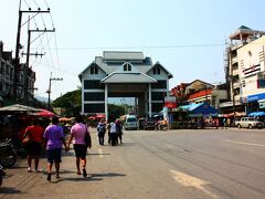 ランチビュッフェの後は30分車で移動をして、ミャンマーとの国境の町：メーサーイに。
中央に見える巨大な門は、タイとミャンマーをつなぐイミグレの建物。
別途料金を支払えばミャンマー側へも連れて行ってくれるようだけれど、自由時間が30分しかないのでまた別の機会に。
メーサーイは写真に写っているパホンヨーティン通を中心とした街で、イミグレの建物を付きあたりにして、左右には様々な商店や小売業・市場が立ち並び大変賑やかだった。

