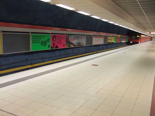 地下鉄のホームに、電車が入ってきたところ。<br /><br />広告のデザインがかっこいい。<br /><br />地下鉄の車両デザインは、<br />ANTTI NURMESNIEMI(アンティ・ヌルメスニエミ)。<br />サウナスツールとか、日本でも人気の<br />ほうろうポットとかをデザインした方です。