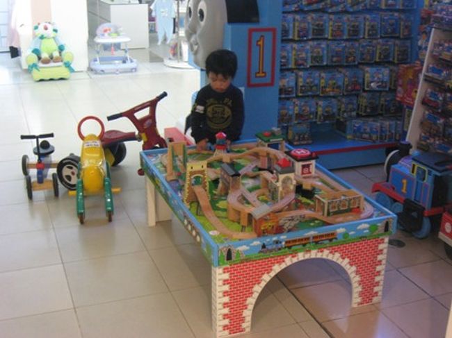 もう一度おもちゃ屋さんに行きたいたいと言うので、弊店間際のおもちゃコーナーへダッシュ。<br />っていうかもう照明落とされてるし…。<br /><br />トーマスの線路があるコーナーなんですが、ここでトーマス機関車を買わないと遊べないようになっているんですよ。<br /><br />仕方ないので買いました。日本で買うより割高かも〜。