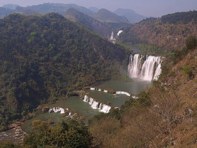 ケーブルカーを降りると、この景色！<br />九龍十瀑　南国一絶<br /><br />十段の滝があるそうだ。<br />天晴れのスケール！<br />まるで巨大な龍が天に向かい飛び立とうとしているようだ。<br />写真一番上に見える情人瀑まで階段を下り散策路を歩いて滝見物といこう。