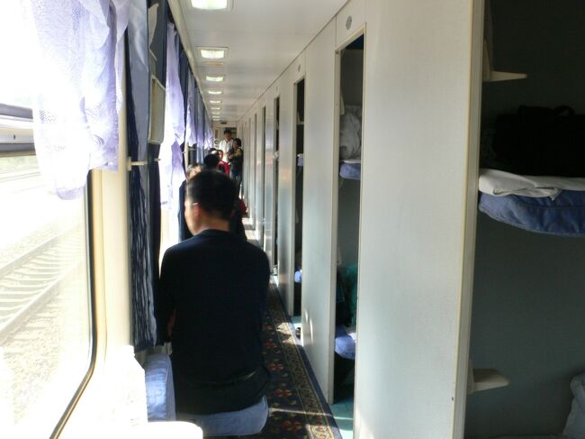 硬臥<br /><br />廊下の補助椅子に腰掛けて外の車窓を眺める光景は日本と同じだ。<br /><br />写真右下のコップ置き場のような棚状のものが梯子代わりで、ここに足を乗せて上段に上がる。<br />私には無理だと思う。