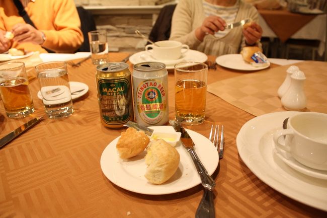 コタイジェットに乗る前に、当然のように香港のガイドさんから「はい。お願いしますね。」と、コタイジェットの乗船券をツアー人数分渡される。<br /><br />「どうして？」と聞いたら、「ツアー名簿の一番先頭に名前が有るから」と当たり前の様に言われたので、妙に納得してしまった。<br /><br />何でも「17時45分になったら、代表として待合所の入口で席を予約してね。」だって。<br /><br />そんなこんなで、香港からはコタイジェット約1時間で無事マカオに到着。<br /><br />イミグレは一切問題なし、今までのイミグレ経験では一番早く通過。<br /><br />マカオに到着したら早速バスに乗って夕食だ！。<br />マカオ料理だった。<br /><br />なにはともあれ、ビールビール！<br />代表的なビール「MACAU」と「青島」2種類を飲み比べた。<br /><br />う〜む。びみょう〜〜。<br />敢えて言うなら「青島」かなぁ。<br /><br />グラスに注がれたビールに「泡」が無い事で、この微妙さ加減をお判り頂けるでしょうか。<br /><br />写真のパンは焼きたてを貰った。<br /><br /><br />他にも↓