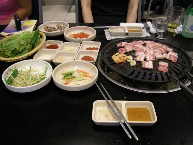 こんな感じでおかずは少なめ。美味しかったけど、済州島の黒豚がやっぱり絶品ね。<br />隣に手話で会話している若者女の子グループが居ました。観察していると２人は日本人、２人は韓国人らしいということが分かったので、日本人の子に「手話は日本と韓国同じなの？」と聞いてみると「同じものがたくさんあるので通じる」のだそうです。その子達と色々お話して楽しいひと時でした。
