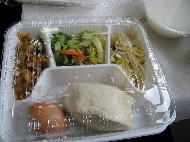 本日の朝食<br />写真に写っている暖かい弁当＋お粥がついてくる。<br />この頃になると給湯設備が混雑する。そう大半の人がインスタント麺をすするのである。