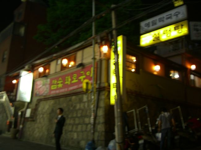 「ん〜、面倒だから、タクシーで行こう」<br />ホテルのすぐ前に止まっている、「模範タクシー」と言われている黒塗りのタクシーに乗り込み、「ここに行きたい」と告げる。<br />しかーし、この「模範タクシー」のオヤジが、クセモノですた。<br />地図を見せたのに、どこだかわからない様子。わざわざ店に電話して、場所を確認。それでもわからないらしく、ナビに店の電話番号を入れて、検索。<br />そんなことをしながらも「江南ニイイ店ガアル。ソッチニ行カナイカ？オイシイヨ」とか、薦めるしまつ。<br />「アニダ！(いいえ)ドゥータで買い物する」と言ったら、黙ったけど。<br />それにしても、えらく遠いなぁ・・。いくら道がわからないとしても、徒歩でも行ける距離なのに。<br />ようやく着いたときには、メーターが5000W以上になってた。「あのじじぃ、おかしいぞ。ナビと反対の方向にばかり行ってた。」後で夫が言う。<br />親切そうに、つたない日本語でペラペラしゃべっていたのは、注意を逸らせるためか？