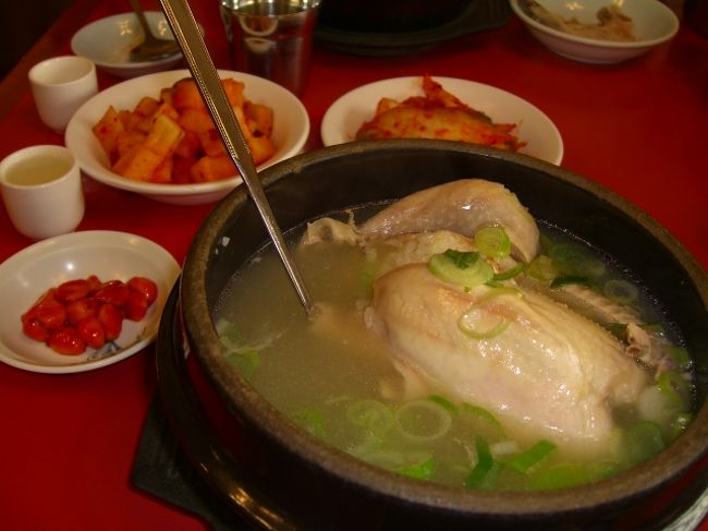 しばらく待ってると、ブクブク湯立っている鍋のまま、鶏の丸茹でさんがお出まし。「うっわっ！すっごっ！！」ちょっとびっくりww。<br />おばさんは、小皿に塩と胡椒を入れて、スプーンでまぜ、それを鍋に入れた後、残りの塩コショウに鶏肉を取って、「付けて食べろ」とジェスチャーしてくれた。<br />( ﾟДﾟ) ﾑﾎｰ 食べ方は、わかった。鶏肉を箸で取って、食べる。ここでも、塩がおいしい。ただ塩をつけただけなのに、何でおいしいんだろう？骨をガラ入れに入れつつ、鶏の中のもち米をスプーンですくいつつ、キムチもちょいと摘みつつ。<br />朝鮮人参が入っていたので、初体験ww。「(*゜・゜)ンッ?ぐにゃぐにゃ・・・」あまーりおいしいものではなかったww。てか、味ないしっww。<br />食べてる間、おばさんはどこかに行ってしまってて、丁度食べ終わった頃に、また出てきた。見えてたのかな？ww<br />料金を払って出る。「マシソヨ(おいしい)」と言うと、うれしそうに笑ってくれた。