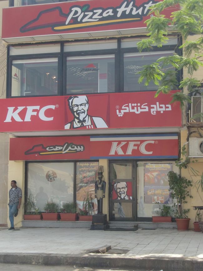 スフィンクスの側の入り口前にはKFCとピザハット。<br />カーネルサンダースはいません。<br /><br />なんか、ピラミッドの横とかスフィンクスの前にマックとかケンタッキーがあると勘違いしてる？会社の同僚がいたけど、そんなところにはありませんのであしからず。。。<br /><br />スフィンクスからは２〜３００ｍくらいは離れてます。<br /><br />まあ、ピラミッド＝砂漠のどまんなかのイメージから来てるのか？