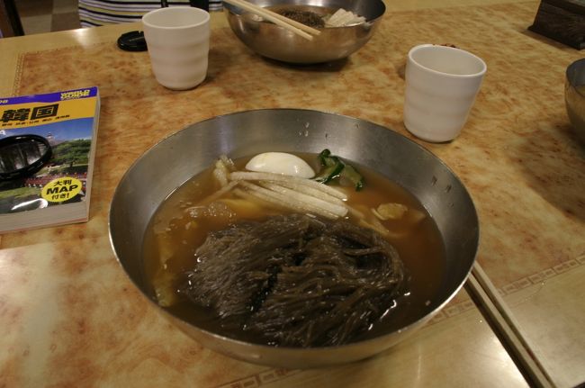 市街地、駅近くにある「平壌冷麺（ピョンヤンネンミョン）店」。平壌式冷麺という種類でＷ６０００。韓国の冷麺は褐色のものが多いです。<br />