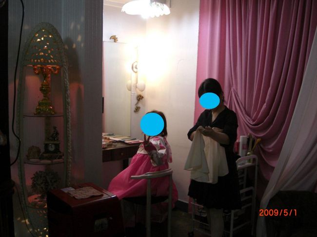 選ぶと、まずはチマチョゴリを着せてもらう。下のロングスカート(チマ)は、胸の上で紐をぎゅっと結ばれた。ちと苦しいww。<br />それから、メイク。スッピンで行ったので、その上から次々と塗り塗りされる。アイラインを引くと、お目目ぱっちりになったww。「つけまつげ」もつけられ、まぶたが重いww。<br />ホテルに迎えに来てくれたおばさんが、覗きに来て、「カワイー」と言ってくれたので、「カムサミダ(ありがとう)」とお礼を言う。