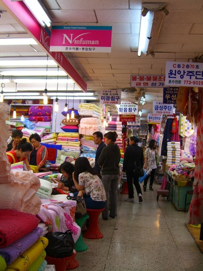 「ぐわー！何ここ。すごい人！」道に露天が並んで、その間を大勢の人が行き来して、なかなか前に進めない。外国人もいるけど、地元の人の方が、圧倒的に多い。<br />しかし、我々が通り過ぎると、何故か日本語で客引きの声が掛かる。何でわかるんだ？<br />「ナンデムン(南大門)市場」での目的は、「韓国海苔」と「雑貨」。<br />まず海苔屋さんに行って、見せてもらい、味見して、オススメのやつを買う。次に「みかんチョコレート」が欲しかったので、見せてもらうと、1箱1万ウォンと言われた。<br />「高いねー」日本で買うと、そんなもんだけどねー。つい、チョコってハワイみたいに安いものかと思ってしまう。スーパーのが安いだろうから、そこで買うのはやめて、海苔だけ貰って後にした。<br /><br />次に向かうは、「雑貨」やさん。前もって調べた雑貨やが、C棟の2階にある。でも、中はかなり複雑で、「迷子になる可能性高し！」だそうで、覚悟して入って、階段で2階に上がる。だいたい、入口見つけるのにも、苦労したよ（;´Д｀）<br />2階に上がったはいいけど・・さて、どこだろう？動物的カンで、ただまっすぐ進む。<br />「本当にこっちでいいのか？」と迷いながらも、ここまで来ちまったら、仕方ない。迷子になっても、いつかは出られるだろうさ。ゆっくり進みながら、看板はハングルなので理解不能。店番号の数字だけを頼りに、「ｷﾀｷﾀｷﾀｷﾀ━━━(ﾟ∀ﾟ≡(ﾟ∀ﾟ≡ﾟ∀ﾟ)≡ﾟ∀ﾟ)━━━━!!」(　ﾟдﾟ)ﾋﾞﾝｺﾞｰ　ああ、なーんて、いいカンしてんでしょ、私って♪<br />うれしくなって「あれも、これも！」と、巾着やポーチやストラップ等を、買い込む。