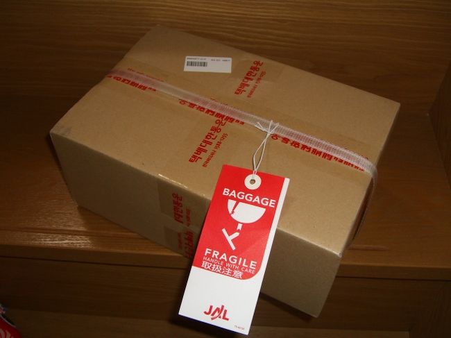 空港に着き、JLのカウンターでチェックイン。それから、手荷物検査場へ。私は難なく通過したけど、夫の荷物が引っかかる。<br />係り員が、かばんの中を調べて、「これは？」と振る。「マッコリ」と答えた私は、「はっ！」とした。<br />あ゛―――！しまった。液体を、手荷物にしちゃったぁーーー！！<br />NYテロ以来、液体のチェックは厳しくなり、今では、100ml以下の液体しか持ち込めない。それを知っていたのに、つい忘れてた。<br />てか、こないだまで、お酒やら、壊れやすい物は、手荷物にするのが、常識だったぢゃんっ！！その癖がポロっと出てしまった。<br />「もっかい、カウンターに戻って、預けて来い」と言われ、エアチケットにスタンプを押されて、外に出された・・・。初めてだよ・・・ (´･ω･`)ｼｮﾎﾞｰﾝ<br />JLのカウンターに行くと、「このままでは預かれない。ラッピングして来い」と言われる。「どこで？」と聞くと、「あっちに行け」と、向こうの方のカウンターを指示された。<br />言われたカウンターは、一番端っこ。そこまで行くのが、遠い・遠い。<br />「まったくっ！何でこんなことにっ！」いや、そりゃあ、我々が悪いんですけどねっ！わかってますよっ！そーよ、私が悪いのよっ！でもさっ！つい「こないだまで」そーだったぢゃんっ！酒は手荷物が、常識だったぢゃんっ！！<br />端っこのカウンターに行っても、「アシアナ」のカウンターがあるだけで、どうも違うとしか思えない。仕方ないので、近くのインフォメで聞くと、「向こうに宅配やがある」「宅配にするわけではない」「ラッピングもしてくれます」<br />行きますた。してもらいますた。マッコリと同じ料金、掛かりますた・・・・ww。<br />皆様！マッコリは、スーツケースに入れましょう。<br />｡･ﾟ･(ﾉД`)ヽ(ﾟ∀ﾟ )ｱﾋｬﾋｬ<br />再度、JLのカウンターに戻り、「マッコリ」を預けて、セキュリティーチェックに。<br />今度は、無事通れました！！