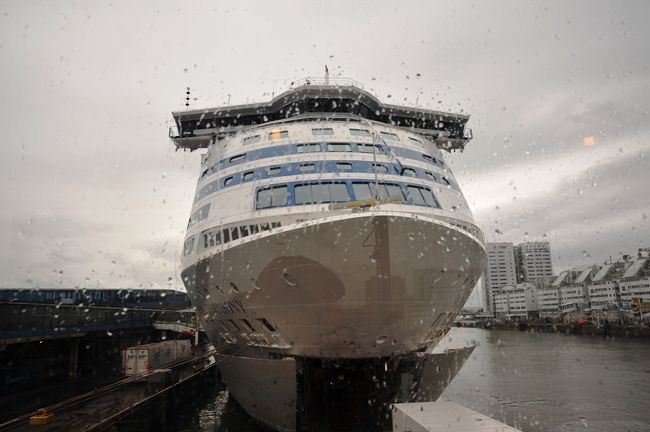 定刻９時半に無事到着しました。<br />１７時間半の長い船旅でした。<br />スーツケースを引いて下船します。<br /><br />このシンフォニー号に乗りました（雨の付いた窓越しに）。この時間９時３７分でした。