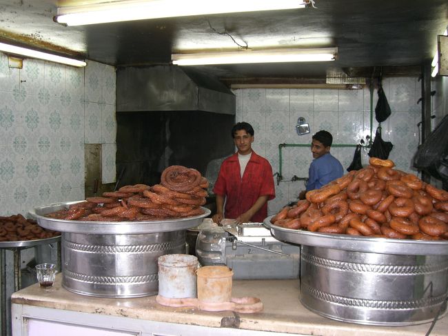 街なかのスークにはアラブ風ドーナツのお店が沢山。ドーナツはあまり好きじゃないので買わないんだけど、どの店も競うようにタダで何種類もくれる。かじると中からハチミツみたいのがトロ〜っと出てきて激甘。気持ちは嬉しかったけど…。<br /><br />明日は電車でアレッポに移動することにしたので、まずはチケットを買いに。鉄道駅は遠いので街中のチケットセンターで購入。場所はアザール広場裏手の小さな薄暗いモールの一角で、時間によっては店員がいないのでやや面倒。