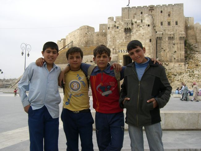 城の前で出会った子供たち。写真には4人しか写っていないけど、実際は20人くらいに囲まれた。この子たちと1時間以上遊んでたなー。<br /><br />それにしてもシリアの子供（男の子限定）は何故タバコを吸っても注意されていないのだろうか。まだ小学生だよ？ぜったい問題だと思うんだけど。