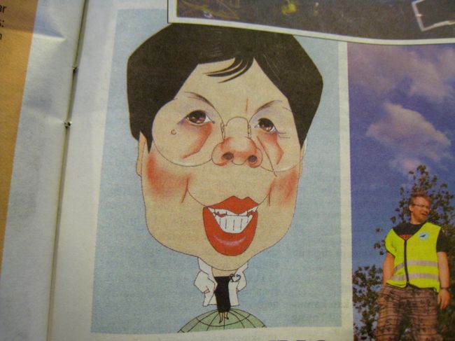 天気予報を見ようと席に置き忘れられていた新聞を開くと、何とも日本のどなたかに似ている風刺画が。本当はWHOの方です。