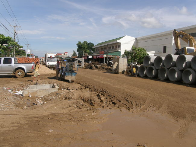 バス乗り場の写真<br /><br />雨上がりの様を呈している。<br /><br />晴れてたけど<br /><br />クロックスが泥だらけになる。<br />これを想定して履いてるから問題ない。<br /><br />＊＊＊＊＊＊＊＊＊<br /><br />なんとなく赤シャツに連れられて<br />やつの勧めるバスに乗る事になった。<br /><br /><br />ひじょーーーーーーに怪しいが。<br /><br /><br />国境を越えた後の広場からバスに5分ほど乗せられて<br />事務所に連れて行かれる。<br /><br />そこでチケットを買わされる。<br /><br />薄暗い待合室？のようなところで<br />同じバスに乗るのであろう、バックパッカーたちが集められる。<br /><br /><br />ほとんどが西洋人バックパックパッカーだが<br />アジア人の女二人組みのバックパッカーもいる。<br /><br />よほど息苦しかったのであろう。<br /><br />目が合うと雪解け水のように話しかけてきた。<br /><br />韓国人かと思ったが、マレーシア人であった。<br />おそらく中国系だろう。<br /><br /><br />余談だが俺はマレーシア語が片言喋れる。<br /><br />NAMA　SAYA　つかったん（私の名前はつかったん）<br /><br />このレベルだ。すごいだろう？