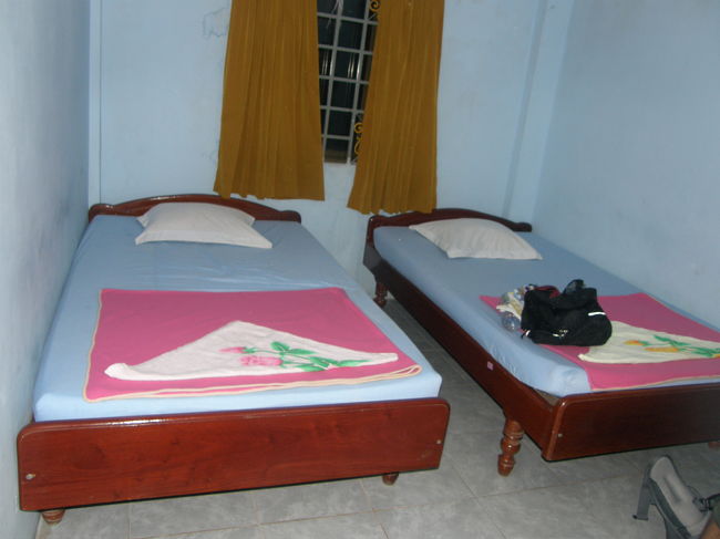 最上階、俺らが泊まった部屋。<br />冷房なし、ほっとシャワーなし。<br />扇風機あり<br />蚊、大量。<br /><br /><br /><br /><br />＊＊＊＊＊＊＊＊＊＊＊＊＊＊<br /><br />しかし、この時間だし、他のゲストハウスを探すのも正直めんどくさい。<br /><br />それにオーナーが日本人の奥さんとフランス人のだんなさんだ。（両人とも帰国してたが）<br /><br />俺らが泊まった部屋は一泊２＄で、冷房・ホットシャワーつきだと５＄なり。<br /><br />オフコース　節約！！！！<br /><br /><br />長旅の旅装を解いているとき、<br />部屋に従業員が訪ねてきた。<br /><br />｢よっ、汚いとこだけど、上がってよ！｣<br />と自宅に友達を呼んだテンションで、<br />（彼女なら、スリッパとクッションを用意しておきます。部屋は掃除しないけど。）<br /><br />いこうとおもったが、<br /><br />よく考えたら、この部屋は彼のものだ。<br />ちなみに彼は自分の名前をアジノモトと名乗った。<br /><br /><br />本　名　は　忘　れ　た　。<br /><br /><br />そして、後で部屋に来て！って頼んだのも俺だった。<br /><br /><br />強ちさっきのテンションも間違えじゃないな。<br /><br /><br /><br />明日以降の観光（アンコールワット）<br />の運転手　兼　ガイドをアジノモト氏がしてくれるというのだ。<br /><br />カンボジアのように、公共交通（特に市内バス・鉄道とか）<br />が皆無のようなところだと、<br />車をチャーターするなどしないといけない。<br /><br /><br />発展途上国は逆に金がかかる。<br /><br />だが、その金で観光産業が潤うなら、大いに有意義な金の使い道である。<br /><br />外国人観光客が公共交通を使えるくらいインフレが整うほうがいいけど。<br /><br />だが、その金を落とすのは外国人観光客が担えばいい。<br /><br />発展途上国にとって<br />観光資源は貴重な財産である。<br /><br />それを活用しないで、どうやって国を成長させていくというのだ。<br /><br /><br /><br /><br />交渉の結果（料金は言い値でOKした。だってカンボジア悲惨で値切る気が起きなかった）<br /><br />明日は<br />片道１時間かけてベンメリアという郊外にある遺跡と、夕日の鑑賞。<br /><br />明後日は1日中アンコールワット周辺を廻る事にした。<br /><br />１日目は38＄　２日目は12＄。<br /><br />もちろん1人あたりだ。カンボジアの物価からすると<br />べらぼうな料金設定である。<br /><br /><br />まあ交渉したのが俺1人だし、（他の奴らは生意気にもシャワー）<br /><br />俺の希望を聞き、ツアーをプランニングしてくれたのもアジノモト氏である。<br /><br />英語上手だし<br />明日以降、彼に任せてみようと思う。<br /><br /><br /><br /><br />よろしく！！！！ <br />