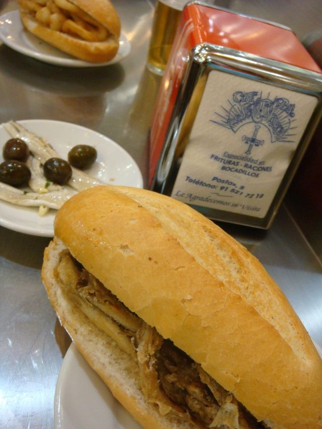 私はこれにしました。<br /><br />bocadillo de boquerones fritos<br />カタクチイワシのフライのサンド<br /><br />bocadillo ボカディージョってこういうパンのスペイン版サンドイッチです。<br />パンには何も塗らないし挟むのも１品だけだし、慣れないと「えー、それだけなの？」って不服に感じますが、パンと中身が美味しいと「なるほど！」って理解できます。<br /><br />