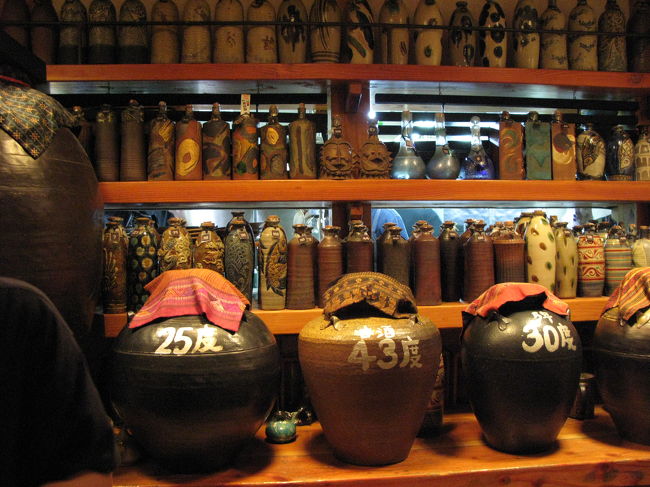 酒場のカウンターには数種類の泡盛の瓶とボトルキープされた小瓶が並ぶ