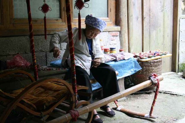 途中、地元民の生活を垣間見ることができました。<br /><br />この方は手作りの草履を作っています（即売）<br />そのほかにも干椎茸や、香辛料なども袋に詰めて<br />売っていました。<br /><br />撮影させてもらったお礼に日本の切手を渡しました。