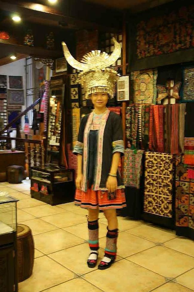 西街のある民芸店へ入りました。<br />ミャオ族の民族衣装や、銀の飾り、刺繍品などがディスプレーされていました。<br /><br />ミャオ族のお姉さんに<br />銀製の冠をかぶって貰いました。<br />「ヘン　ピャオリャン」<br />東洋人には銀が似合いますね。<br />私もシルバーが好きです。<br /><br />ミャオ族は皆、自前の冠やアクセサリーを持っているそうです。また衣装はすべて手縫いで細部まで綺麗に刺繍されています。<br /><br />彼女の衣装はお母さんが縫ってくれたそうで<br />襟元は擦り切れるほど<br />大事に着ていました。<br /><br />中国で一番おしゃれな民族と言われるのが納得できます。<br />刺繍のお土産を幾つか購入しました。