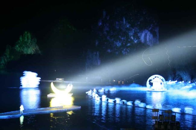 陽朔へ戻り、野外ナイトショーへ。<br />「印象劉三姐」は映画監督の張芸謀（チャンイーモウ）が監督したそうです。<br /><br />中国国内からも続々と見物に来る位の人気で、前日チケットを手配して貰う時にはあと１席しかないと言われましたが、本当に本当だったみたいです。<br />私の席は、ＶＩＰの席の前席で、籐の椅子を幾つか並べたところにありました。<br />つまり、このステージはあまりにも大きくて、前方席では見えず、後方へ行くほど値段が高くなるのです。ここに観客４０００人収容され、出演者４００人がステージへ。とてもスケールの大きいショーでした。<br /><br />湖面には中国の少数民族が代わるがわる登場します。歌を歌う民族、銀の冠をかぶる民族、長い髪を洗う民族…<br />さらに驚くことはその背後に、山水画が広がること。ライトアップされた山並みが時折浮かび上がります。<br /><br />これは内緒で夜景モードで撮りました。ちょと手振れしてしまいましたけど。<br />