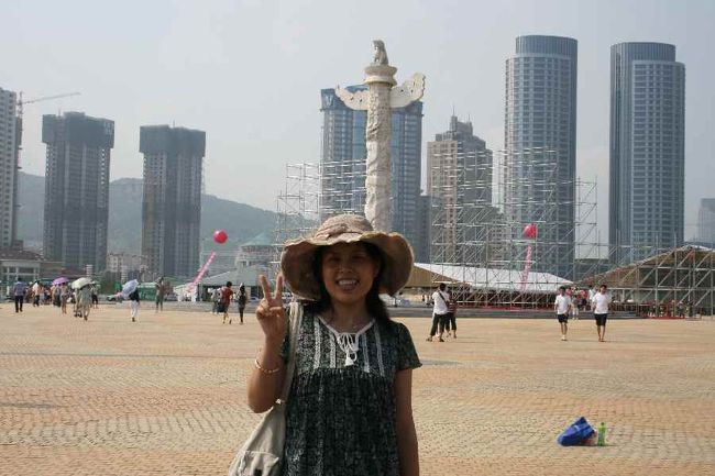 写真は星海広場<br />香港返還を願って建てられた塔は<br />１９９７年の数字が幾つも取り入れられていました。<br />香港の方向（期待する方角）に向かっているそうです。香港返還の前年に香港を訪れました。その頃中国は香港返還を待ち望んでいたのでしょう。<br /><br />この近くに卸売市場があり、一般人も入館できました。彼女がブレスレットを選んでいました。<br />それは私への贈り物だと言って。<br /><br />そこでも値段交渉ができますが、<br />購入後、お母さんがコツを彼女に教えていました。<br /><br />「もし欲しいなら、あれこれ選ぶ前にまず値段を聞く。<br />あれかれ選んでからいくらか尋ねても安くしてくれない」と。<br />相手がもう買うつもりだと分かれば<br />安くしてくれないですよね。<br />そうやってだんだん買い物上手になるのでしょうね。<br /><br />とはいえ、やはり卸です。<br />同様のブレスレットが空港にも売っていましたが<br />１０倍の値札が付いていました。