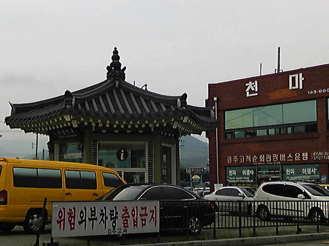 韓国滞在４日目。<br />釜山から慶州（キョンジュ）へ日帰り。<br />慶州は、古代史に出てくる新羅の都です。<br />写真は慶州のバスターミナル。<br /><br />釜山のノポドン・バスターミナルからたった１時間で行けるとは予想外だった。<br />慶州のバスターミナルにタクシーの客引きが待ち構えており、１日チャーターして１２万ウォン＝９千円くらいか。見どころはあちこちに点在し、移動はしんどかったのでもうおまかせにしたが、イイ運転手さんだった。