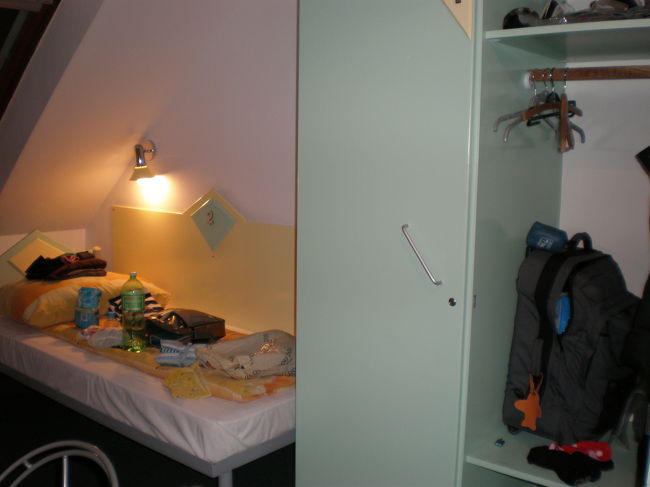 駅から徒歩30分ぐらい。迷いに迷って、暗いなかをおそるおそる歩いてようやく辿り着いた宿。<br /><br />マルコポーロユースホステル。<br />ドミトリーと言えど、ツインルームを2人でシェア。<br />同室の人は、ドイツ語を話すおばちゃん。<br /><br />部屋は快適そのもの。<br />それまでも数ヵ所ユースに泊まったけど、まったく違う雰囲気だった。<br />ベットのある辺りの窓際の壁が斜めになっていて、外から見たら三角屋根？<br /><br />到着後、荷解きして散らかし放題のところをパチリ。