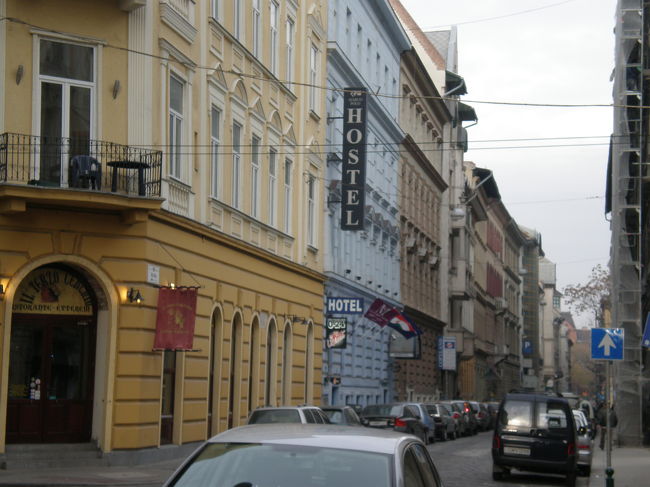 翌朝。<br />ユースの前の通り。<br />ごちゃごちゃしている。<br />色とりどりの建物が並んでいておもしろい。<br />路駐も多い。<br /><br />水色の建物が泊まったところ。<br />朝食は、ユースの隣のミュージックバーにて。<br />正面でなく、裏口から入るよう言われた。<br />（レセプションで確認）※正面は団体客用のブッフェが準備されていた。<br />店内は暗く、煙草臭い…<br />とりあえず、注文しオレンジジュースと変わった形のクロワッサンときゅうり？を。出てくるまで20分待った…<br />遅いから聞いたら、「忘れてた」と…。はぁ〜…<br />