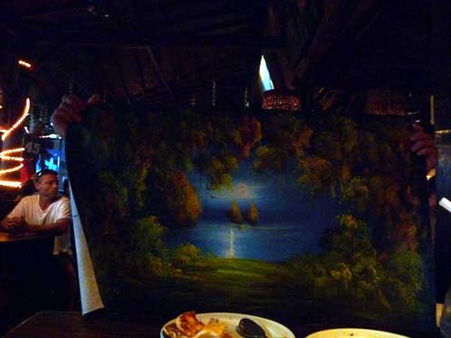 ここは食べてるとひっきりなしに物売りがやってくる。<br />海賊版のDVDやら、自作の絵やら。<br />絵描きを最初は無視してたんだが、よく見ると素晴らしい絵を激安で売っているのでつい見入ってしまった。<br /><br />「あなたが描いたの？」<br />「そーよ　１枚４万ルピア」<br />「上手だね」<br />「そーよ　２枚で６万ルピア」<br />「２枚もいらんよ、置く場所ねえし」<br />「２枚で６万ルピア」<br />「マハール。ドゥアー(高いよ　３万は？)」<br />「２枚で６万ルピア、１枚４万ルピア」<br />「マッハール！スリーハーフよー」<br />「オッケー」<br /><br />結果…よく考えたら5000ルピしか値切ってねえ。<br />２枚で６万としつこく言われたから、なんだか３.５万で値切れた気になっていた。策士めｗ<br />まぁいいわ。<br /><br />売っても良い値段の最低ラインは２万ルピ(200円)くらいみたい。<br />１枚を１時間で描くらしいよ！<br /><br />買った絵はこちら。