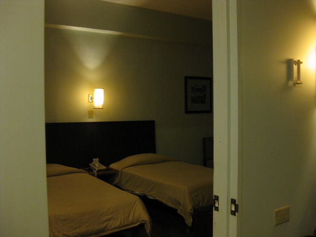 コネクティング・ルーム<br /><br />部屋に到着したのは１時頃。<br />さて、まずは喉が渇いた〜〜。<br />が、<br />私たちが到着した日は運悪く１Ｆの飲み物自販機が<br />ＯＵＴ　ＯＦ　ＯＲＤＥＲ（故障中）で、<br />さあ困った。<br />最寄りのコンビニまでに道を聞き、<br />パシフィック・プレイス近くのサークルＫ（もどき？）まで、緩い上り坂をとぼとぼ歩いて買い出しに。<br />玄関を出た時、ゴロゴロ・・・ピカっ！と<br />いや〜な感じの空だったけど、雨はまだ<br />降り出していないし、<br />水１滴さえ持っていなかった私たちは、<br />「今行くしかない！」と出かけました。<br />はい、<br />もちろんやっぱり、雨季ですから！<br />店内にいるうちに降り出し、あっという間に大雨。<br />！雷雨！<br />道路は川となり、ジャバジャバ。(＠_＠;)<br />飲み物も買えたし、早くベッドで休みたいよう〜。<br /><br />「今帰るしかない！」<br />「走れ〜〜！」ジャバジャバ・・ひえ〜。(>_